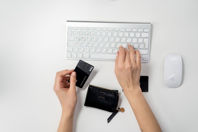 Online shopping at Amazon: A person holding a credit card and typing on a keyboard